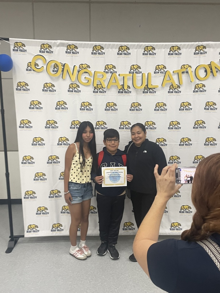 Student holding award with family