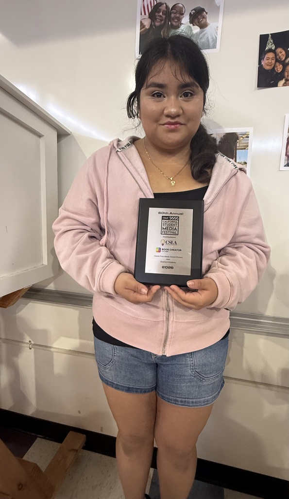 student posing with an award