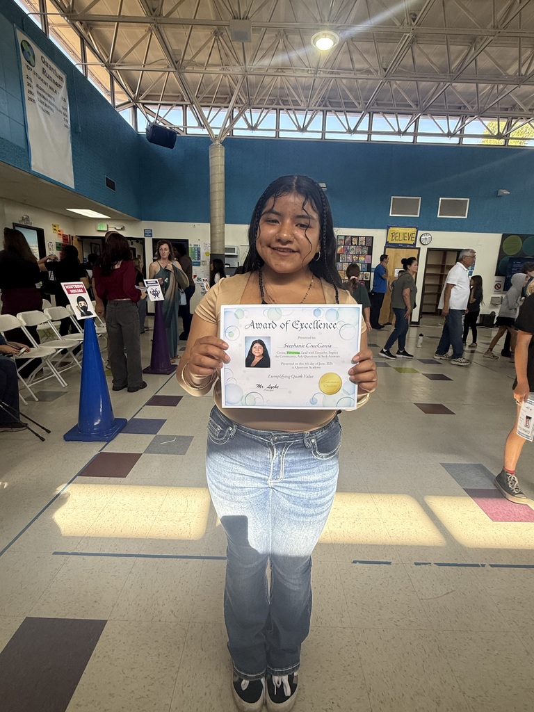 student posing with an award