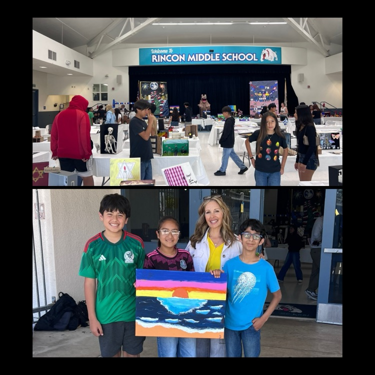 students holding a painting created for their principal 