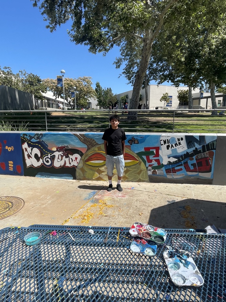 student standing in front of art work