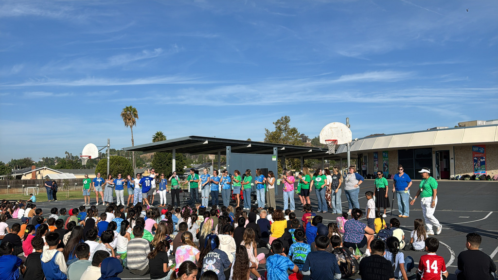 Picture of staff up on the stage during a school wide assembly.