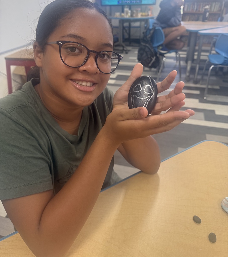 students posing with a rock