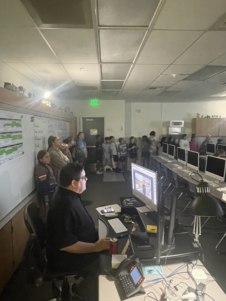 Teacher explaining something to class using computer