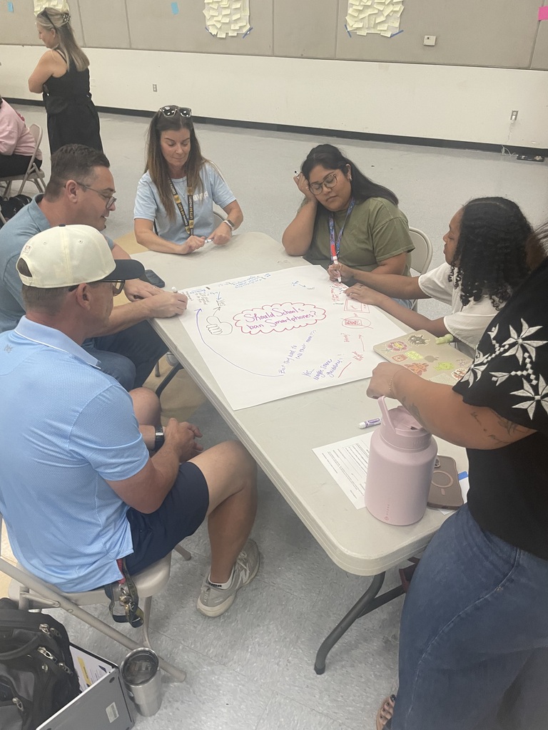 teachers working on a project at their table in a group