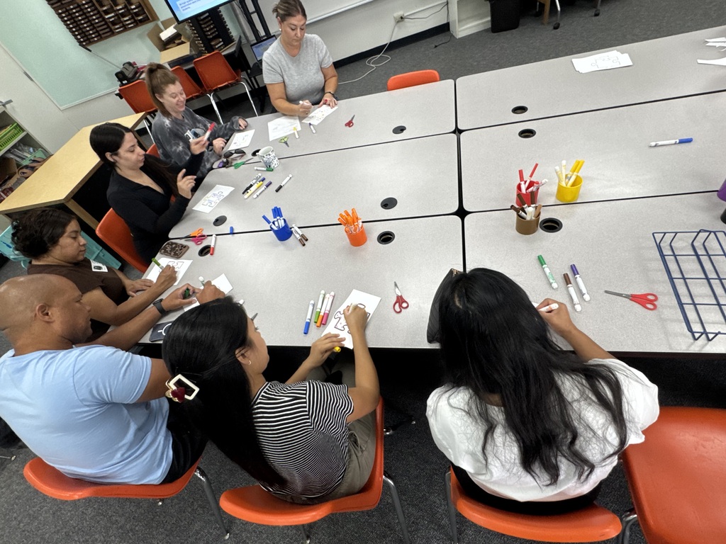 Parents creating a puzzle piece in a classroom.