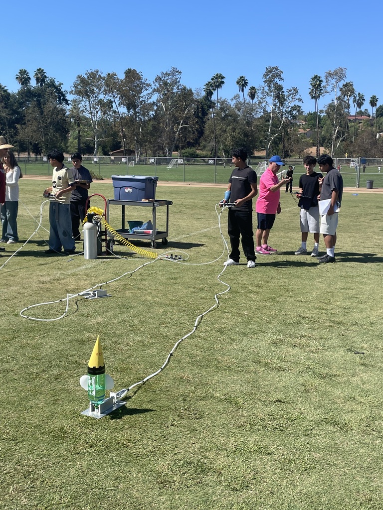 Students preparing to lunch rockets on field