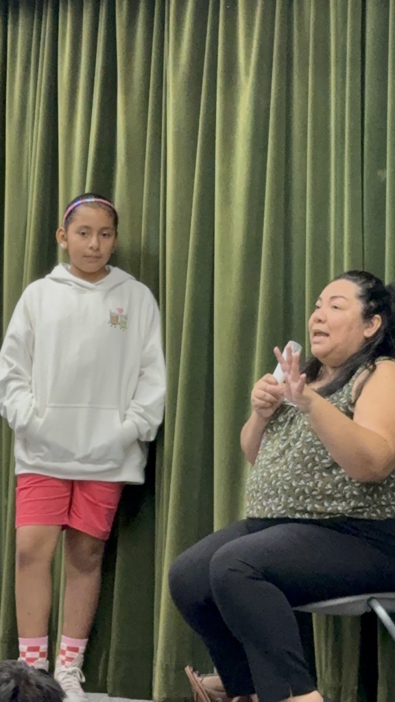 Council woman on the right side wearing green and a student to her right wearing pink shorts and a gray sweater