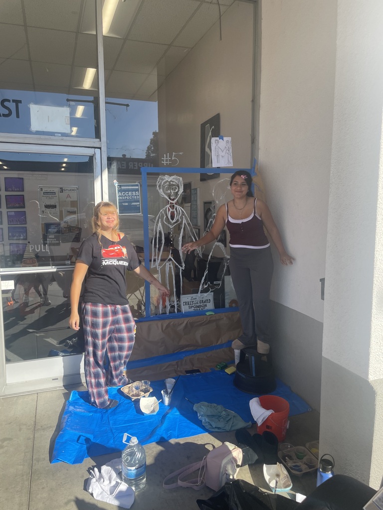 two students painting window
