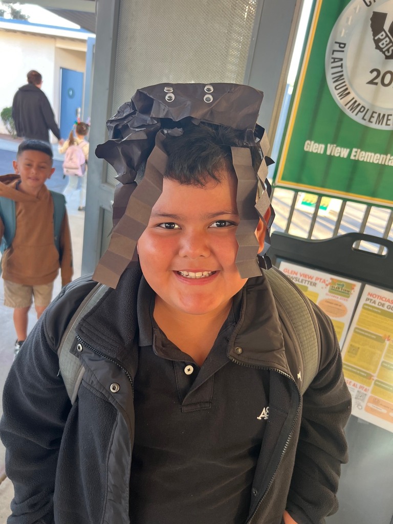 Smiley student wearing black and has crazy hair with spinder on top of head