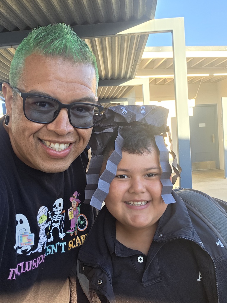 On left side there is a teacher with green hair and on the right side there is a student with a spider on his head