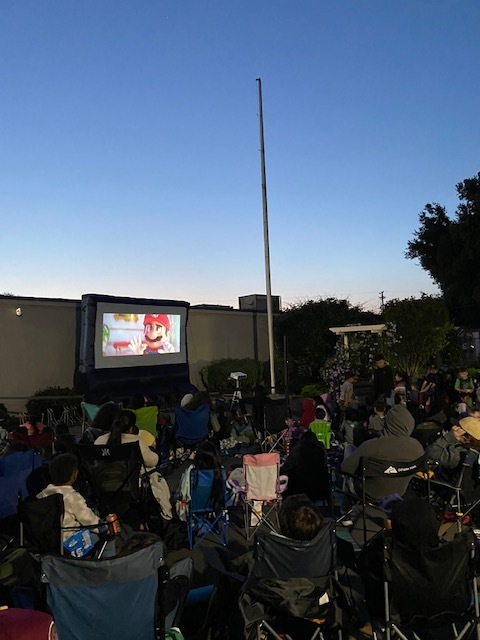 Many people are gathered to watch Mario on an inflatable screen
