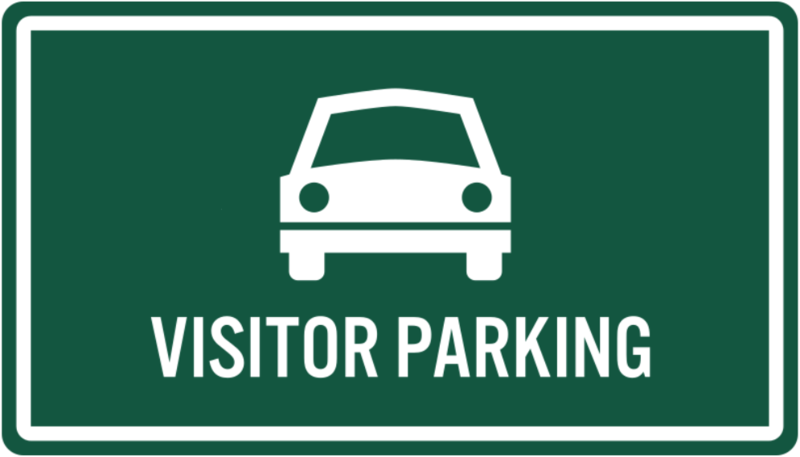 Green sign with white text and car graphic indicating "VISITOR PARKING."
