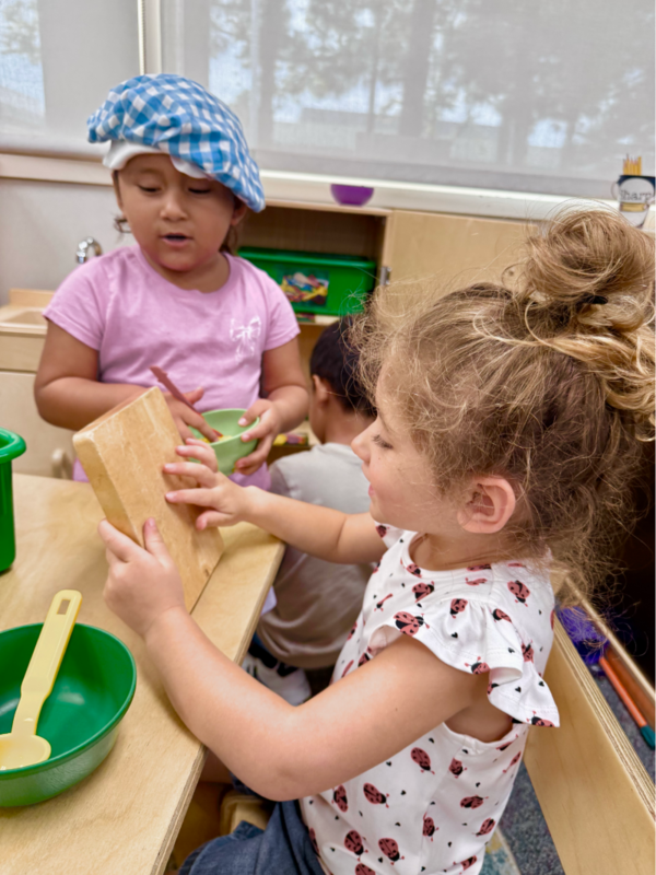 Preschool students learn through play with utensils.