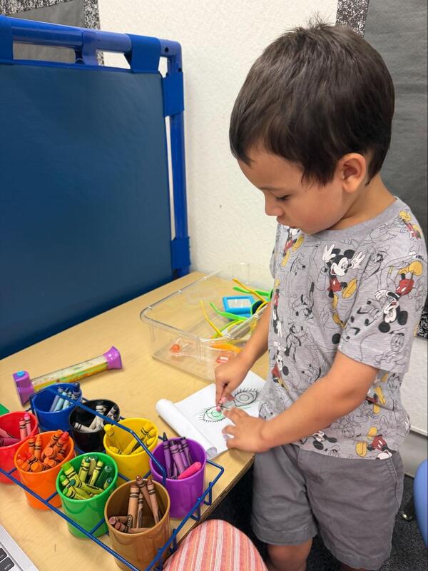 A Transitional Kindergarten student colors.