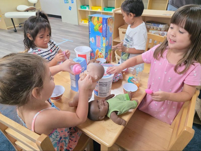 Preschool students learn through play with dolls.