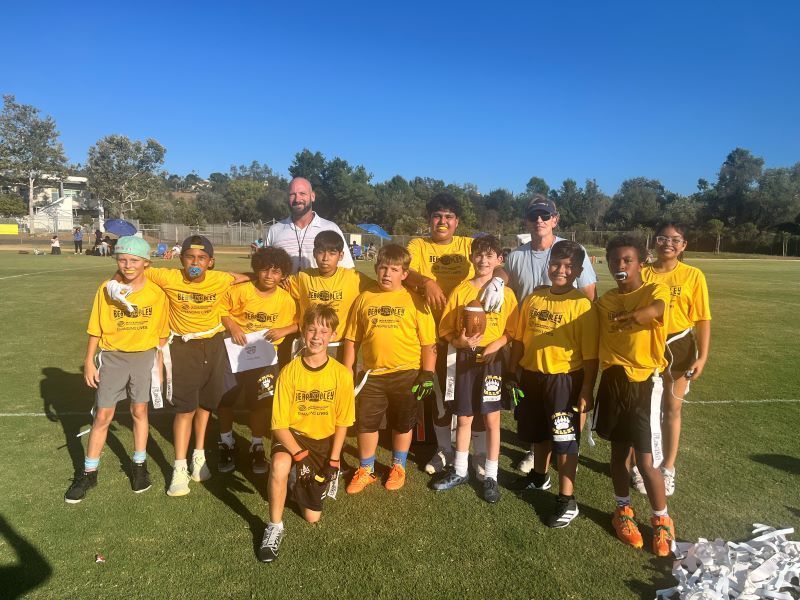 Bear Valley Flag Football Team students pose with their coaches.  Los estudiantes del equipo de fútbol bandera de Bear Valley posan con sus entrenadores.