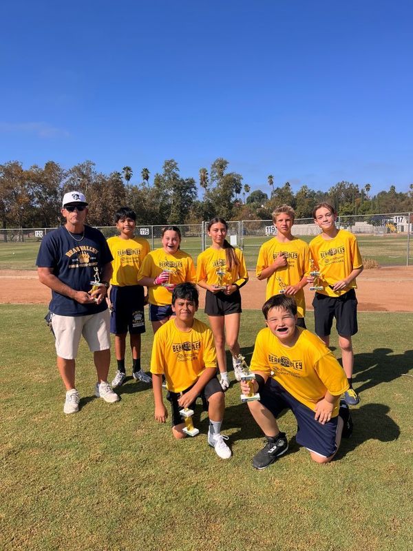 7 football players and coach holding trophies