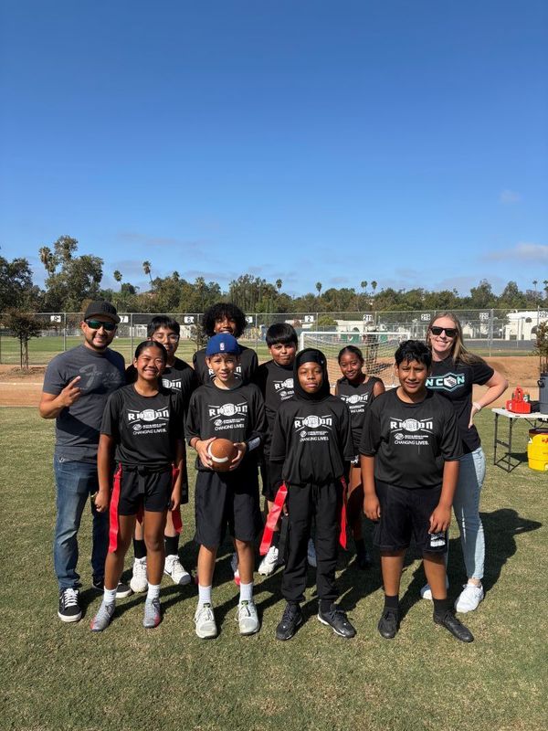 8 football players and 2 coaches holding trophies