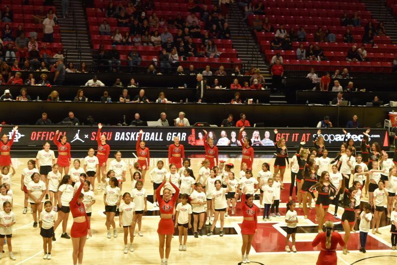 The Felicita Cheer Team joins the San Diego State University Aztecs Cheer Team on the basketball court for a routine.
