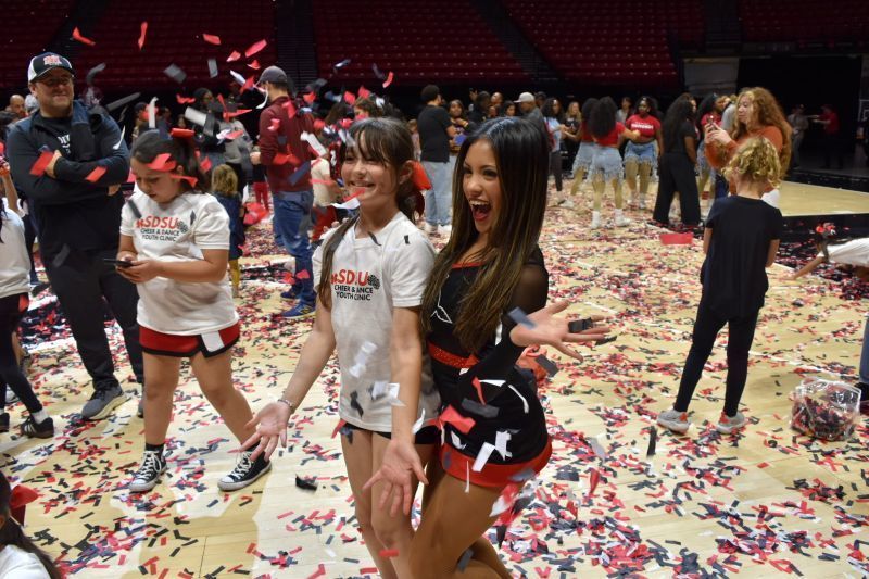 The Felicita Cheer Team joins the San Diego State University Aztecs Cheer Team on the basketball court for a routine.