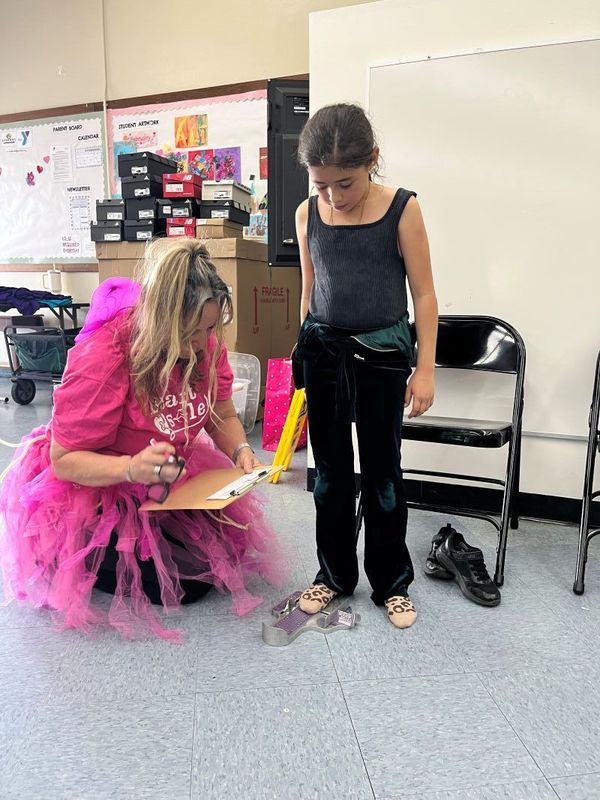 A student is fitted for shoes in preparation for the Girls on the Run 5K.