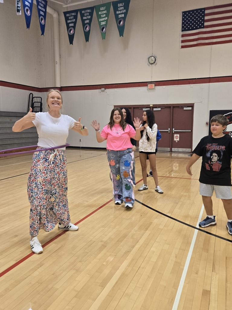 Teacher with students smiling in the gym