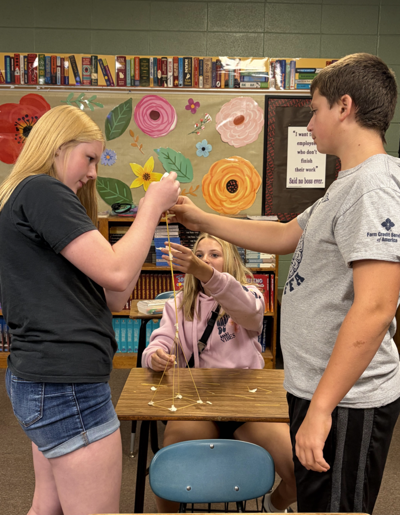 Three students building a tower together