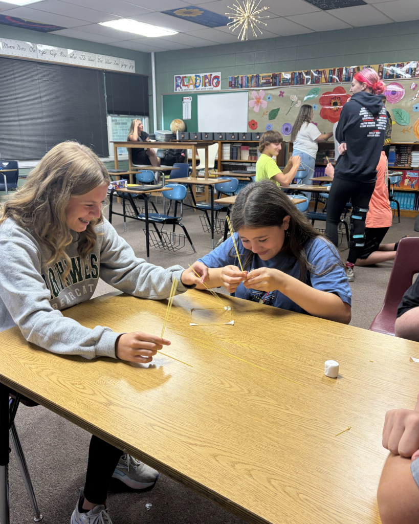 Two students laughing while working on project