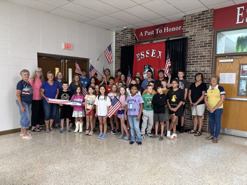 Group of students smiling for a photo with newly donated flags