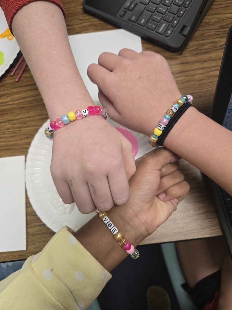 Students showing the beaded bracelets they made