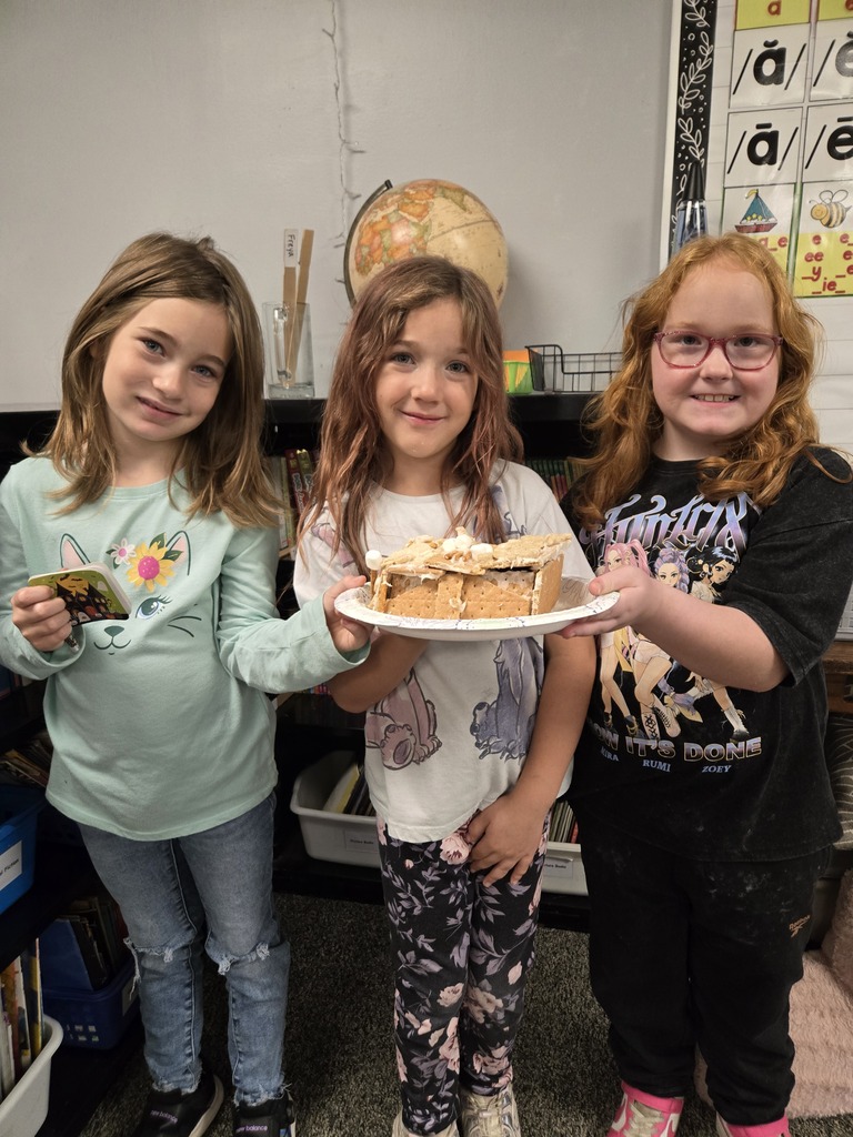 Three students holding their candy house