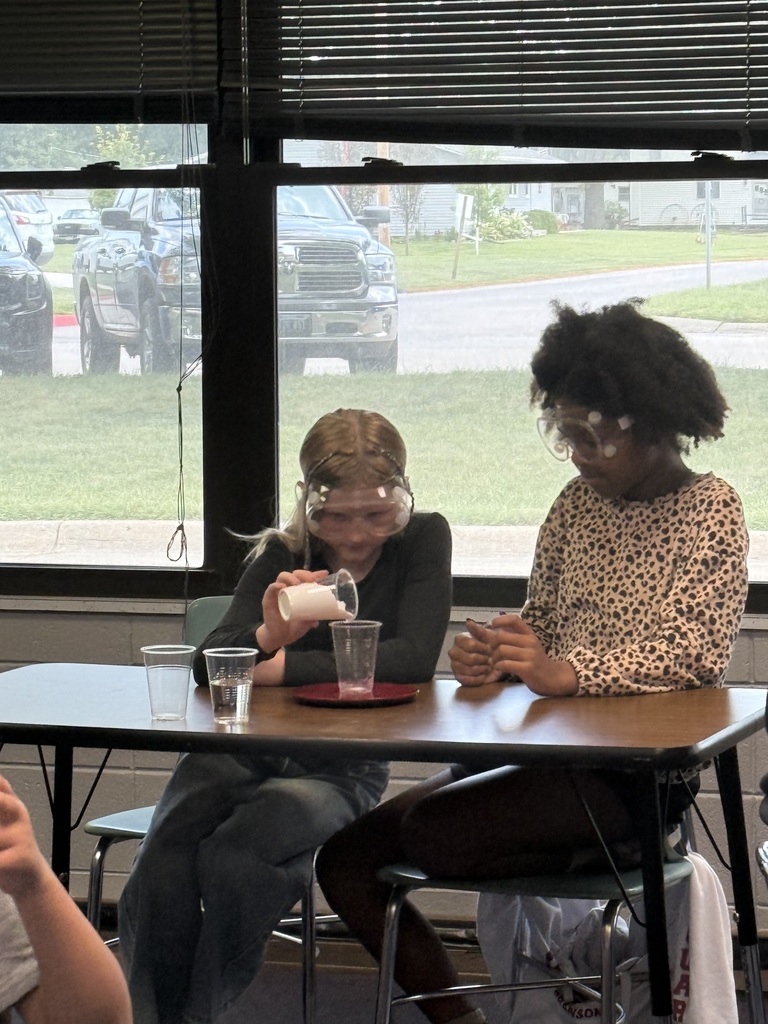 Student pouring substance into a cup for science experiment
