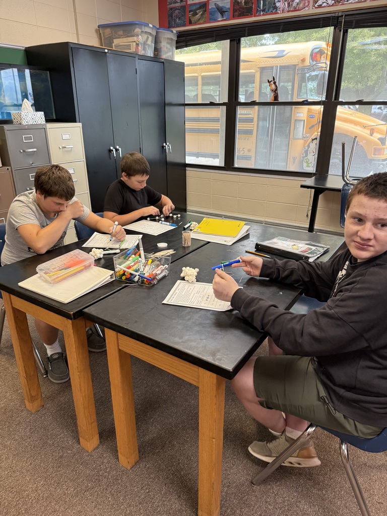 Students sitting at a table making 3D molecules