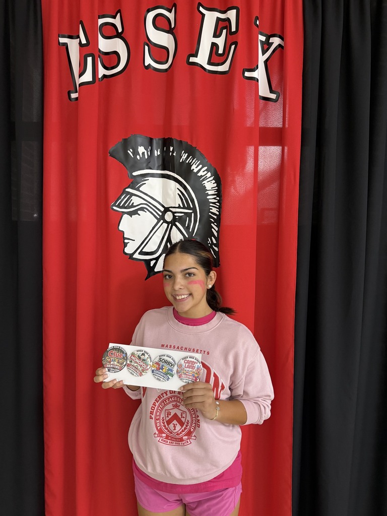 Student holding the buttons that she created in front of an Essex banner