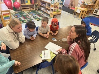 Students sitting at a table with teachers