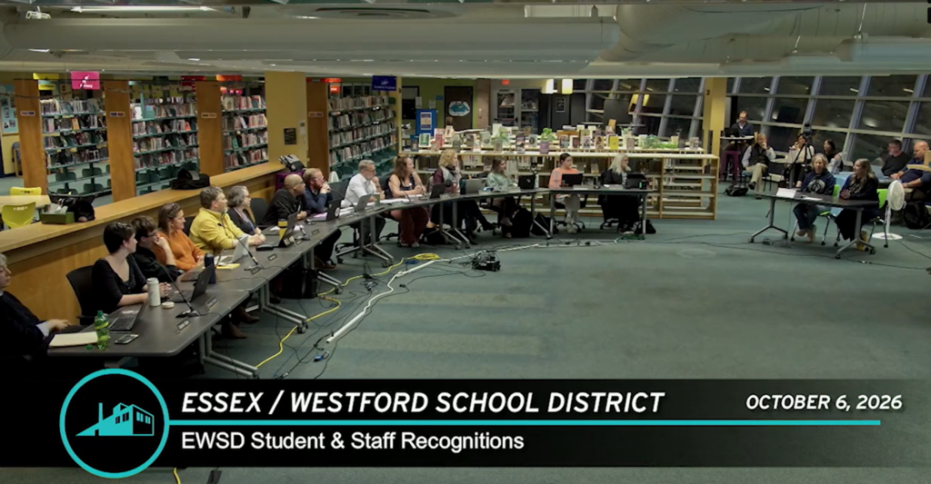 Library meeting with tables. Attendees seated at tables. Some seated in the background.