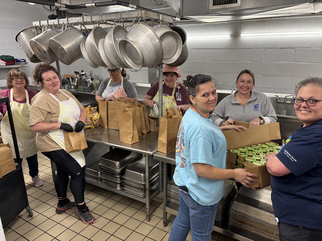 High School Food Service Members working with Assistant Principal, Mrs. Reynolds, to prepare food.