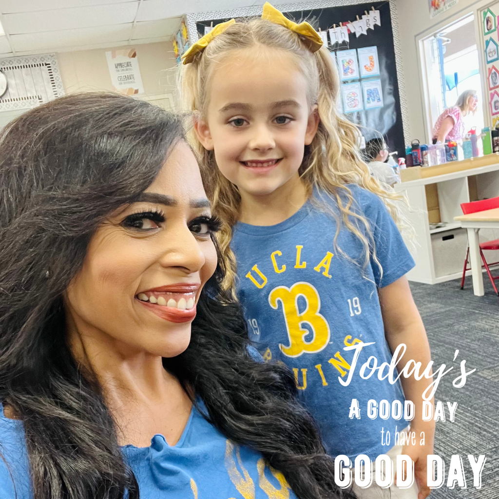 Text: Today's a good day to have a good day. Image: two females wearing matching blue and yellow shirts