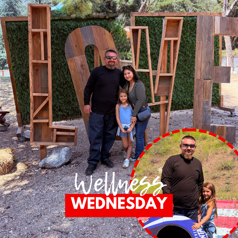Text: Wellness Wednesday Image: three people smiling in f ront of a sign