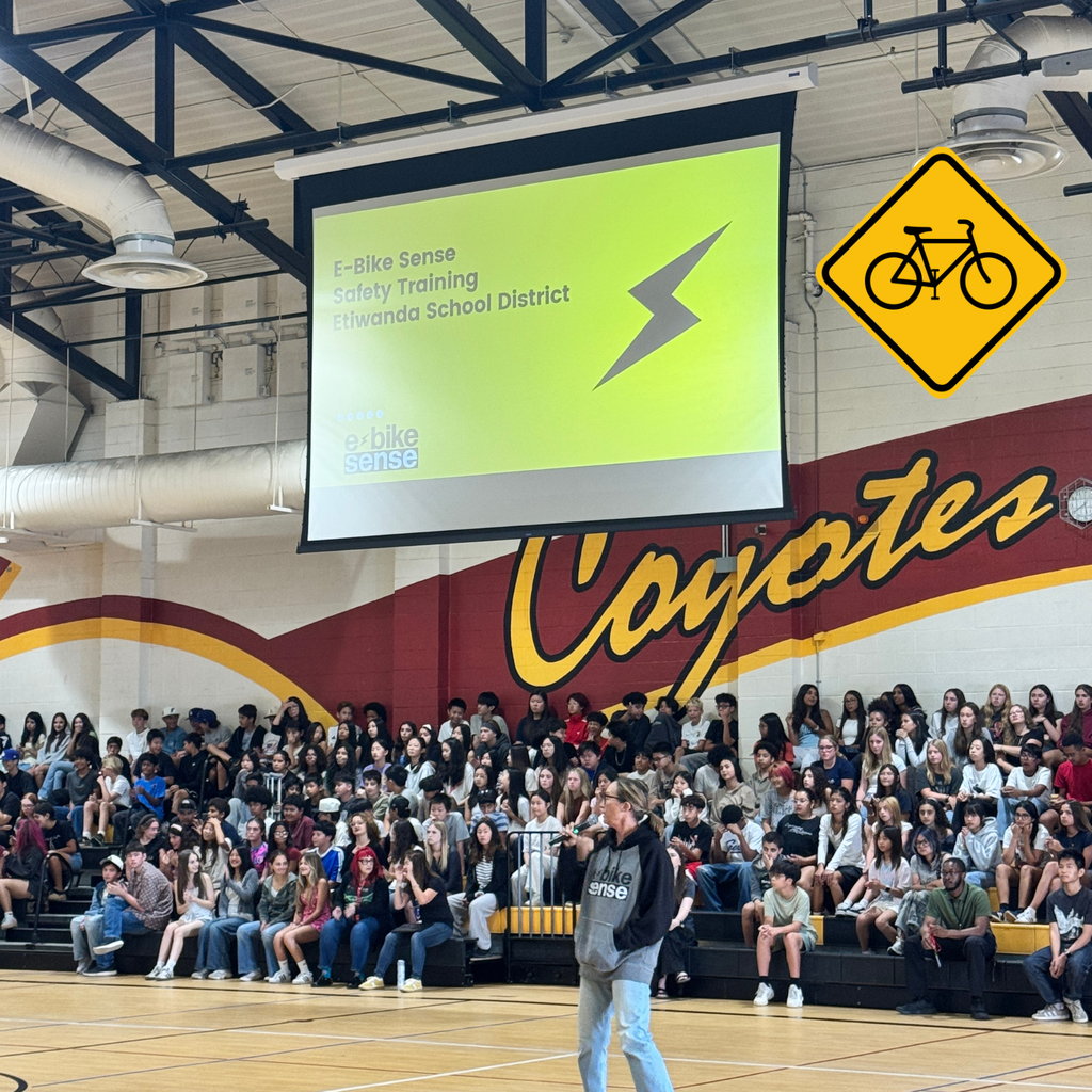 No text: a female on a mic in front of a school