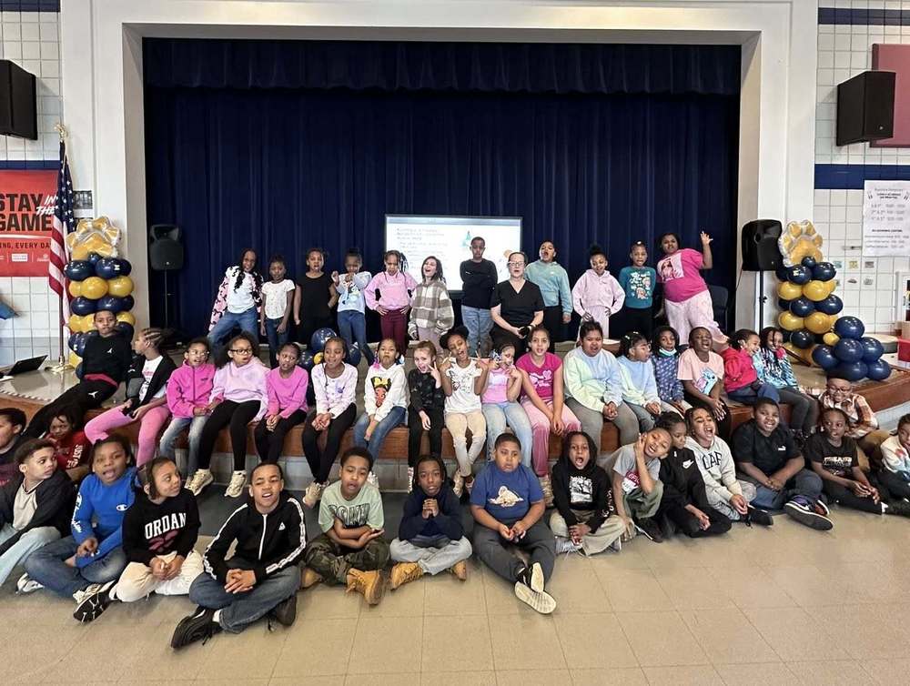 Bluestone students sitting on stage for a group photo with one of their career volunteers