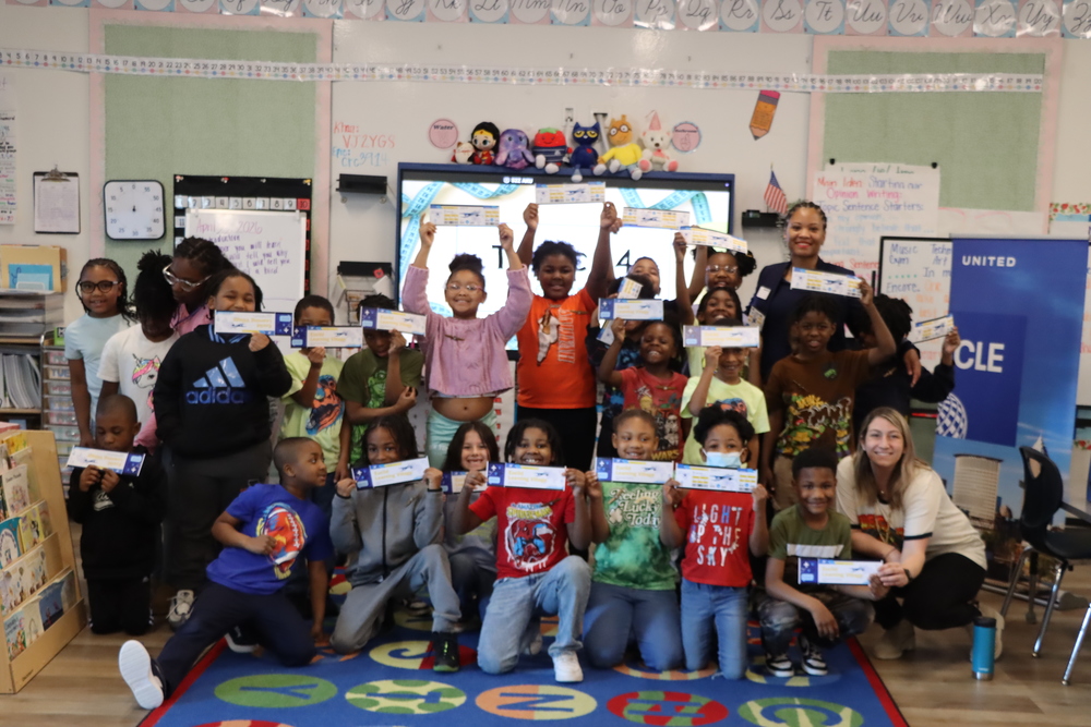 ELV Students holding up fake plane tickets at Career Day with a Flight Attendant.