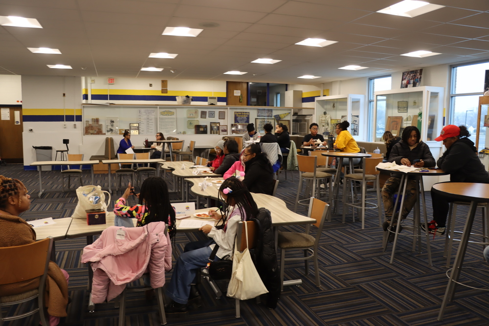 Euclid Middle School families in the Euclid Alumni Room working on projects during the Money Moves Program.