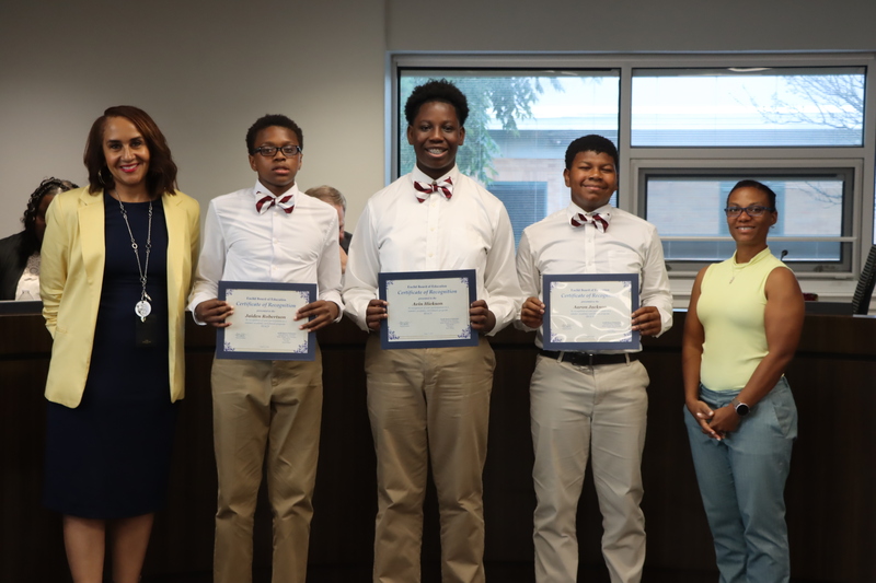 Superintendent Karen Brown, Board President Gabrielle Kelly and the three young men that participated in the REACH program posing for a photo.