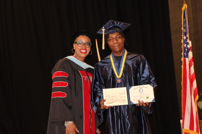Dr. Hayes and a student posing with their diploma.