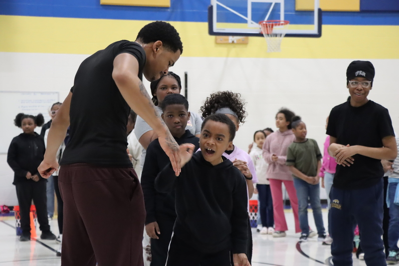 A young Arbor Student high-fiving one of the High School athletes that helped with the event.