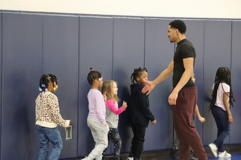 One of the High School Athletes hi-fiving students as they exit the event.