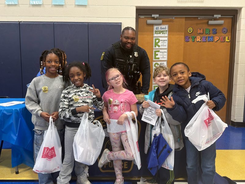 Five Chardon Hills Students posing for a photo with a Euclid Police Officer