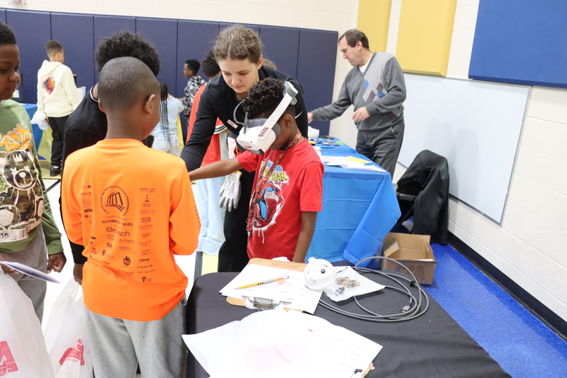 Chardon Hills students watching one of their classmates learn how to use an Oculus Headset from Lincoln Electric.
